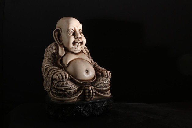 Meditative Buddha statue resting in stillness against a dark background, representing inner peace, contemplation, mindfulness, and spiritual reflection