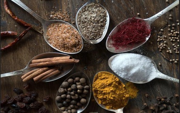 Natural herbs, spices, and healing ingredients arranged on spoons, representing holistic wellness, nourishment, and traditional healing practices